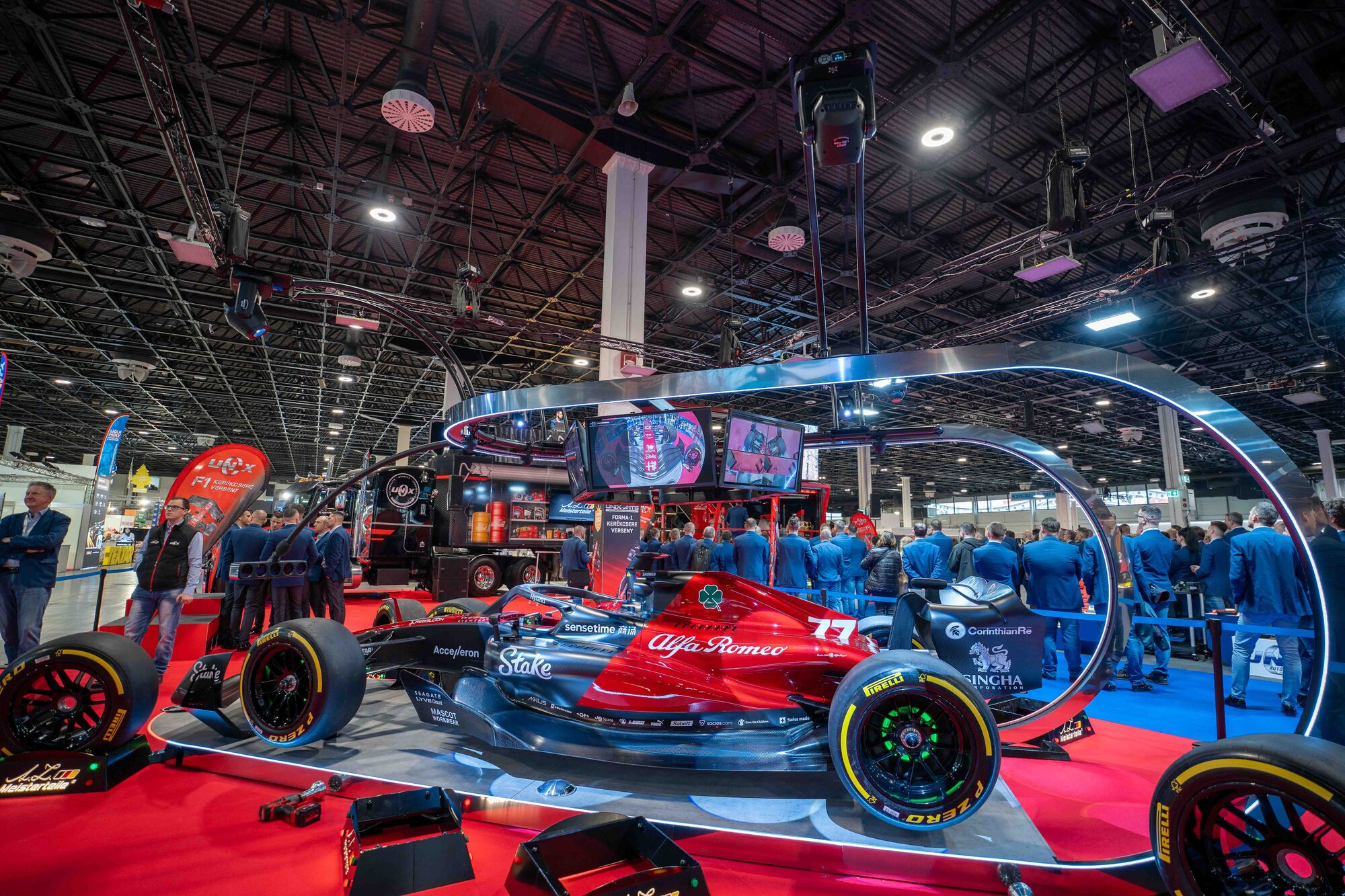 Termékbemutató stand egy Alfa Romeo versenyautóval egy kiállítási csarnokban